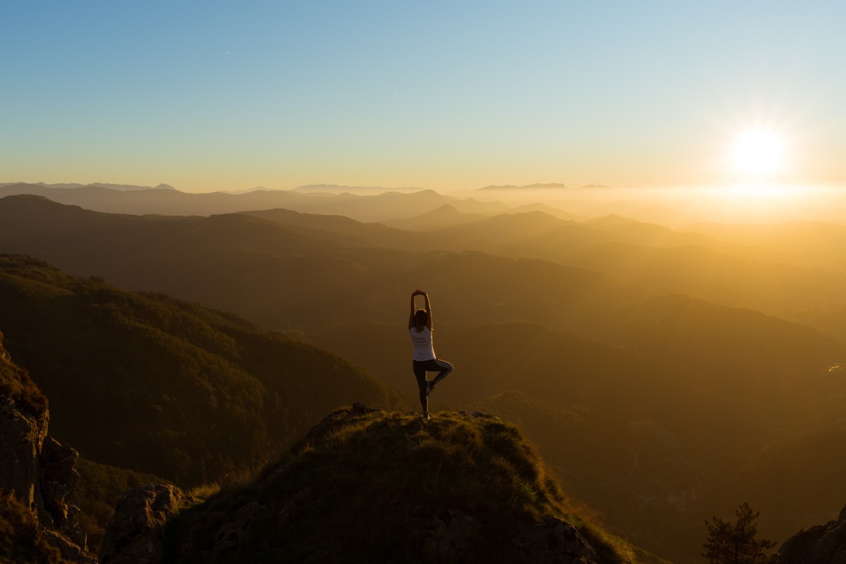 Women on top of hill doing yoga