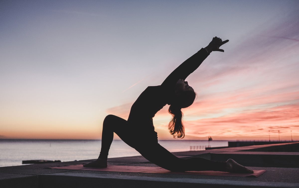 Women doing yoga at sunset